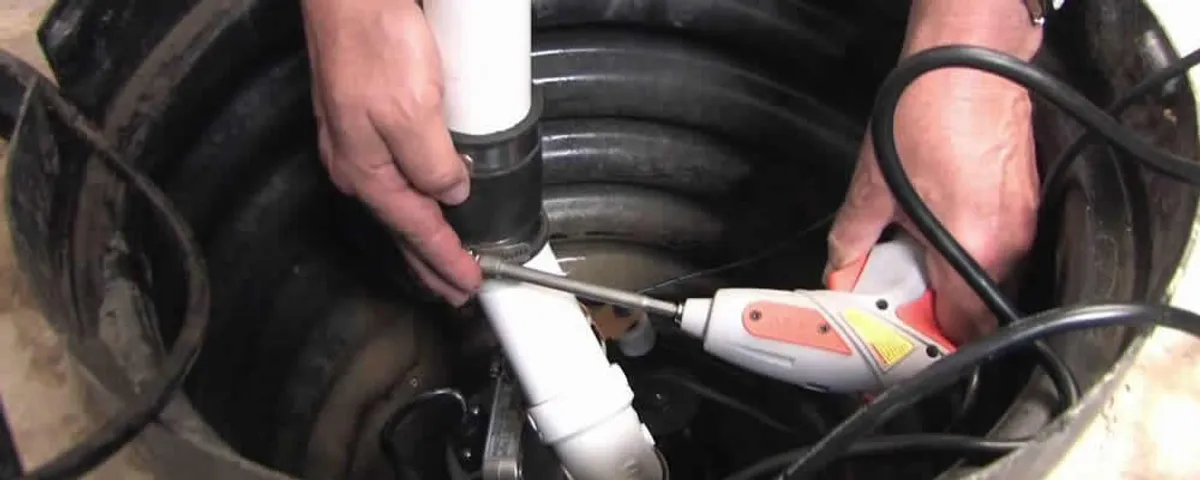 Sump pump installation technician connecting PVC discharge piping in Pasadena, CA